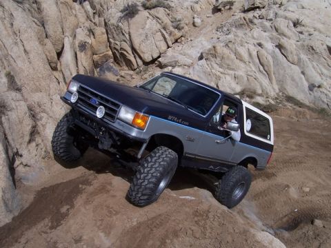 1989 Ford Bronco - This modified Ford Bronco navigates a steep, rocky trail, its off-road capabilities.