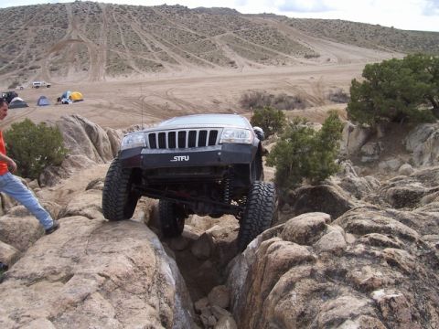 1989 Ford Bronco - Modified Jeep Grand Cherokee tackling a difficult rock crawling obstacle.