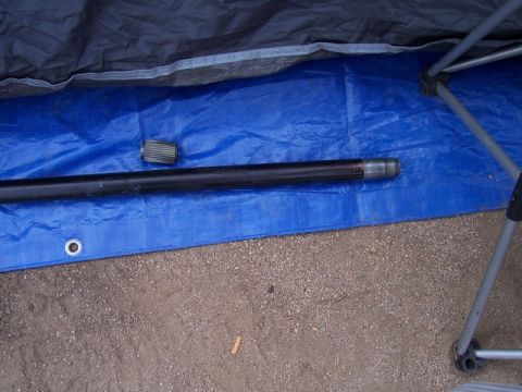 1989 Ford Bronco - A driveshaft and U-joint are laid out on a blue tarp, possibly for repair or replacement.