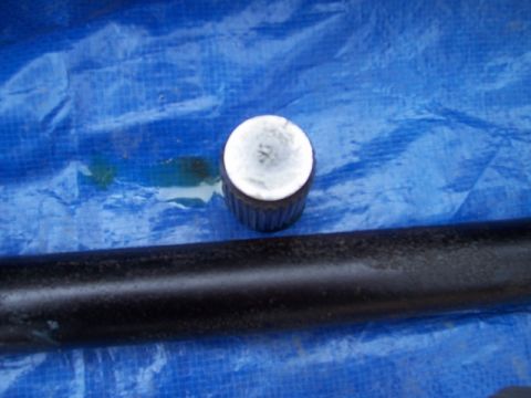 1989 Ford Bronco - Close-up of a metal cap and pipe resting on a blue tarp.