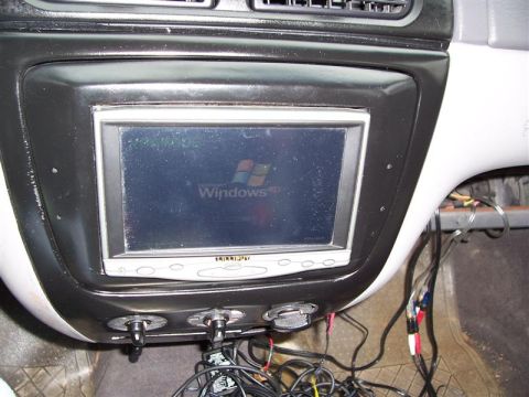 2001 Ford Taurus - An aftermarket car stereo with a Windows XP logo is installed in the dashboard, surrounded by messy wiring and auxiliary power outlets.
