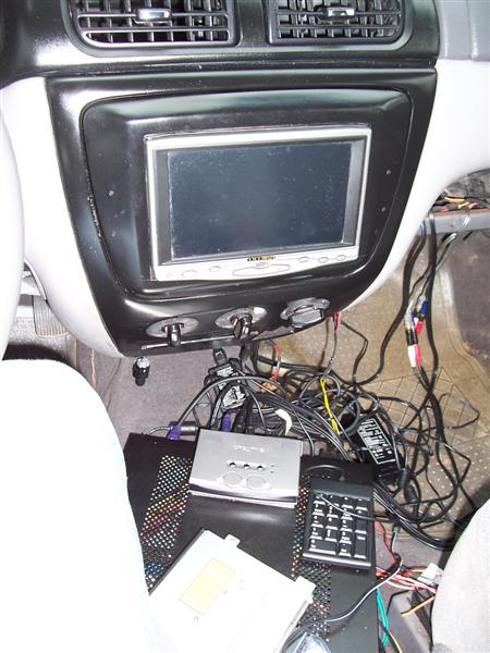 2001 Ford Taurus - The interior of a 2001 Ford Taurus displays a tangled mess of aftermarket electronics and wiring.