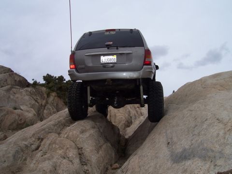 1989 Ford Bronco - Jeep Grand Cherokee navigating rocky terrain off-road.