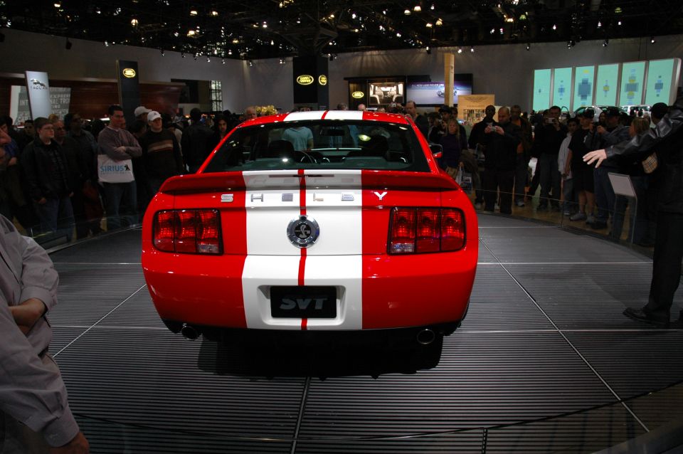 Red and white 2005 Ford Mustang Shelby SVT with racing stripes, rear view