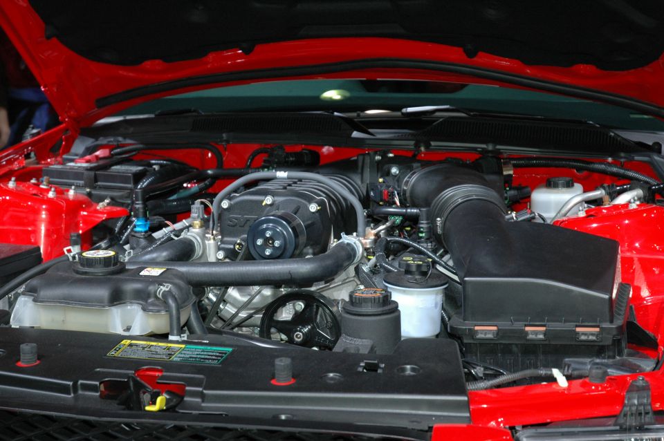 Supercharged SVT V8 engine bay in a red Mustang with hood open
