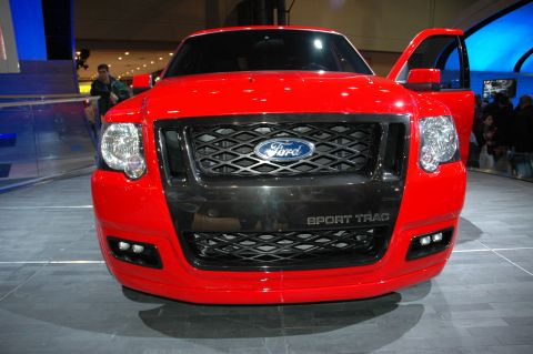 2005 Ford Mustang - Front view of a red Ford Sport Trac with the driver's door open, displaying the Ford logo and 'SPORT TRAC' badging.