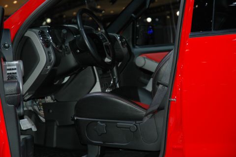 2005 Ford Mustang - The interior of a red vehicle is shown, black seats with red accents and a black steering wheel.