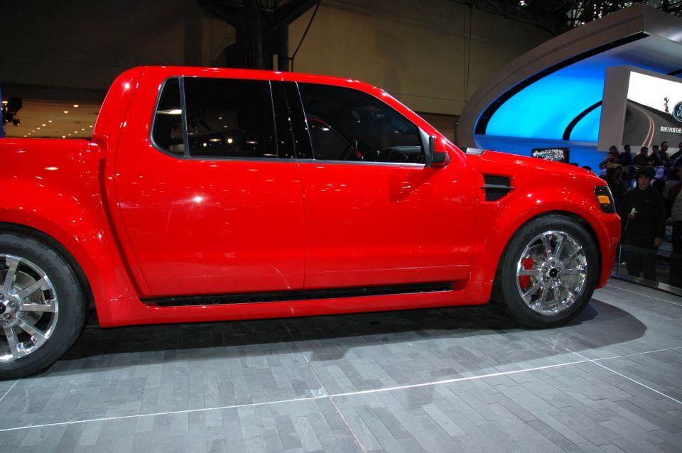 Red Ford sport truck show vehicle in side profile on an auto show stand