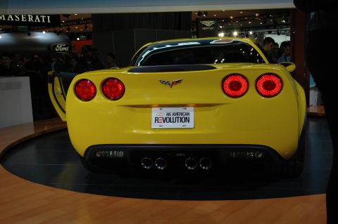 2005 Ford Mustang - This yellow Corvette features a rear view with quad exhaust pipes and a license plate that reads 'An American Revolution'.