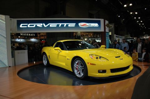 2005 Ford Mustang - A bright yellow Corvette Z06 is showcased on a rotating platform at an auto show.