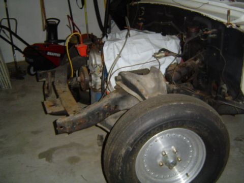 1963 Ford Galaxie - Front section of a car frame with engine components visible, undergoing restoration.