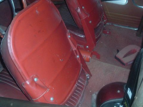 1963 Ford Galaxie - Interior view of a car, showing red vinyl seats and carpeting. A website logo is present.