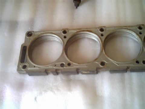 1963 Ford Galaxie - Close-up of an engine cylinder head, showing the three cylinder bores and mounting points.