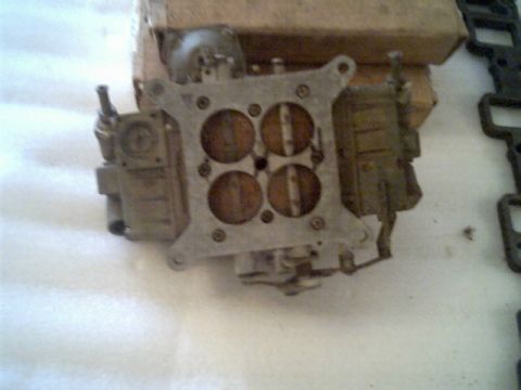 1963 Ford Galaxie - A carburetor, likely for an older vehicle, is shown in a close-up view with a cardboard box in the background.