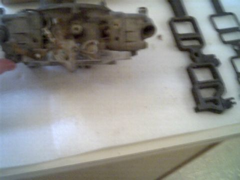 1963 Ford Galaxie - Carburetor and exhaust manifold parts are shown on a white surface, with a Supermotors.net watermark visible.