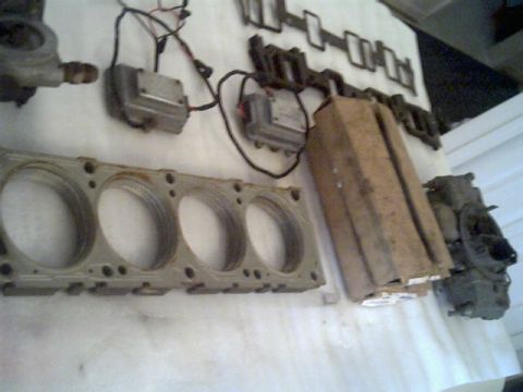 1963 Ford Galaxie - Various engine components are displayed, including a cylinder head and a carburetor.