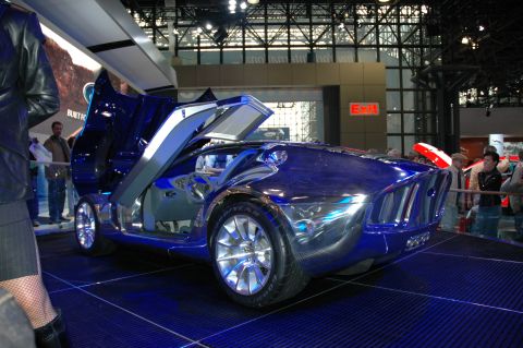 2005 Ford Mustang - A futuristic concept car with unique doors is displayed at an auto show.