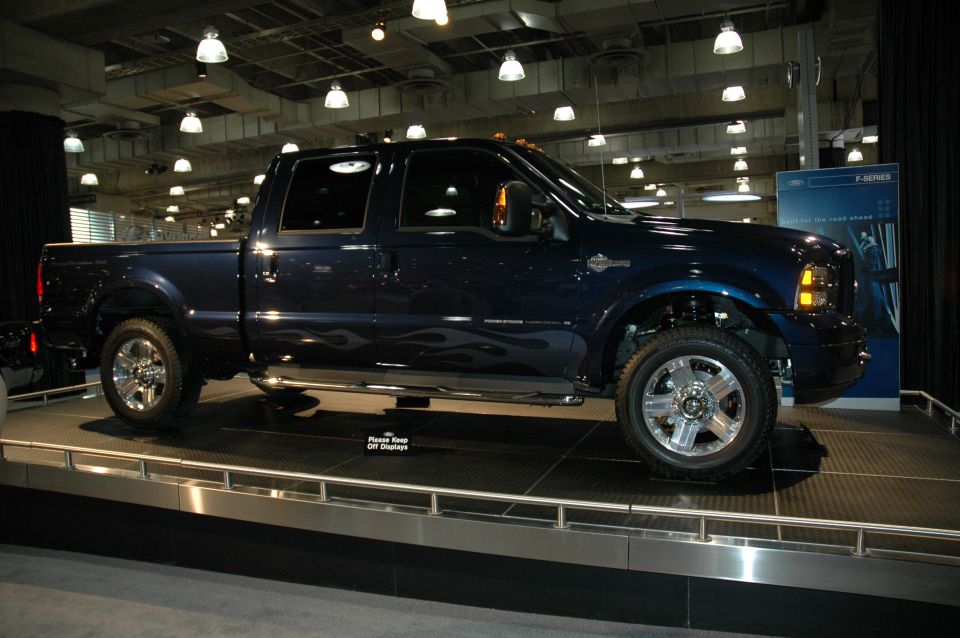 Dark blue pickup truck with flame decals on display