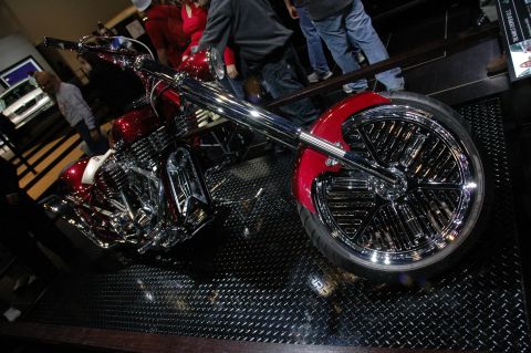 2005 Ford Mustang - A custom chopper motorcycle is displayed on a diamond plate floor.