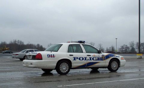 1998 Ford Crown Victoria - A 1998 Ford Crown Victoria police car from Louisville Metro is parked in a lot, with another car visible in the background.