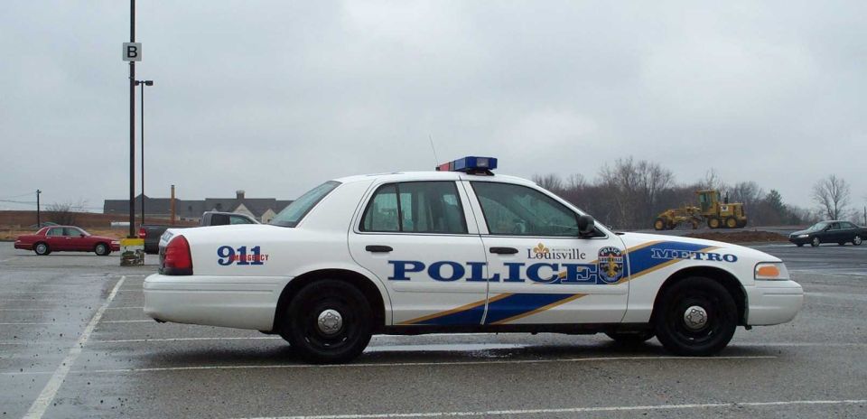 White Louisville Metro Police Crown Victoria sedan, side view, in empty parking lot