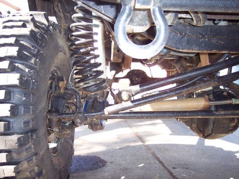 1974 Ford Bronco - Detail shot of the suspension and steering system of an off-road vehicle, showing heavy-duty components.