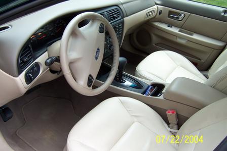 2000 Ford Taurus - The interior of a 2000 Ford Taurus features light-colored leather seats and a beige dashboard.