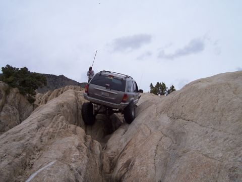 1989 Ford Bronco - This Jeep Grand Cherokee is navigating a difficult rocky terrain during an off-road excursion.