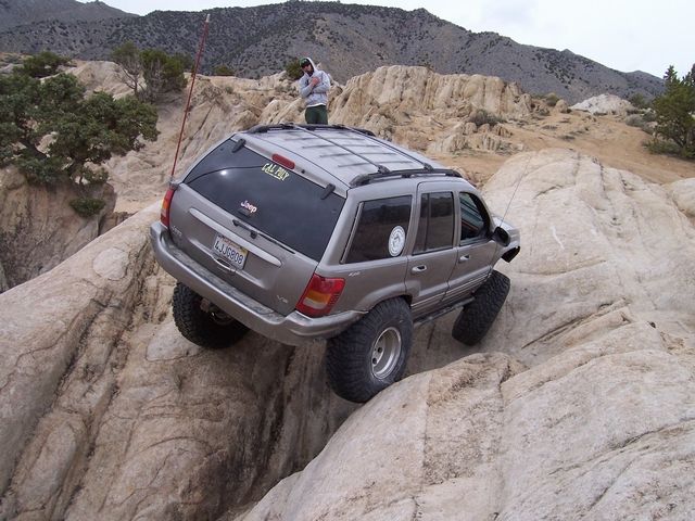 Jeep Grand Cherokee on rocks, driver on roof