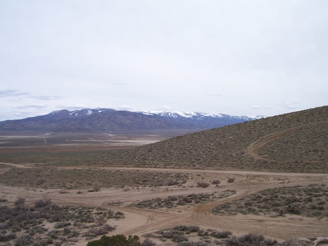 Desert landscape with mountains in the background and dirt roads in the foreground