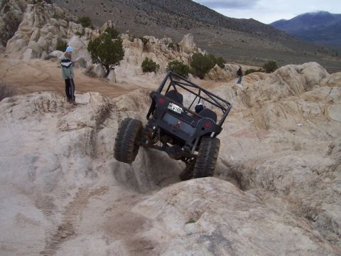 1989 Ford Bronco - An off-road vehicle navigates a challenging rocky landscape, demonstrating its climbing capabilities.