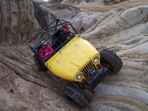 1989 Ford Bronco - This modified off-road vehicle navigates a rocky incline, its capabilities.