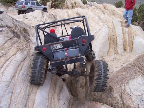 1989 Ford Bronco - Custom buggy tackling a steep rock climb with another vehicle in the background.
