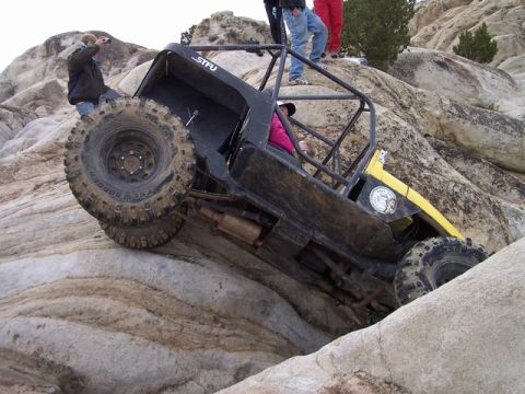 1989 Ford Bronco - Custom off-road buggy navigates a challenging rocky incline during an outdoor excursion.