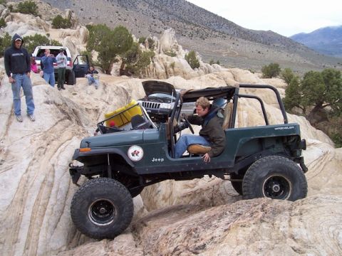1989 Ford Bronco - Off-road enthusiasts tackle challenging rocky trails with modified Jeeps and a pickup truck.