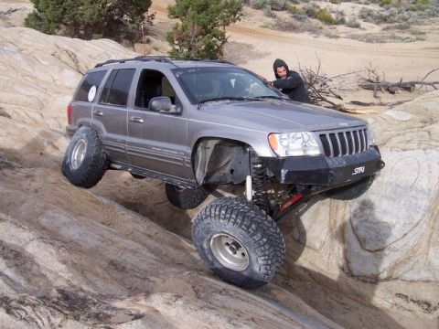 1989 Ford Bronco - A modified Jeep Grand Cherokee navigates a rocky off-road course.