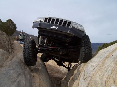 1989 Ford Bronco - A modified Jeep Grand Cherokee navigates a rocky trail, demonstrating its off-road capabilities.