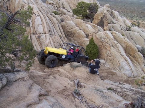 1989 Ford Bronco - A person films an off-road buggy navigating a steep, rocky landscape.