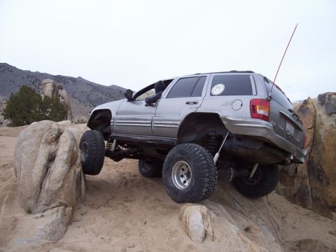 1989 Ford Bronco - A modified Jeep Grand Cherokee navigates a rocky terrain during an off-road excursion.