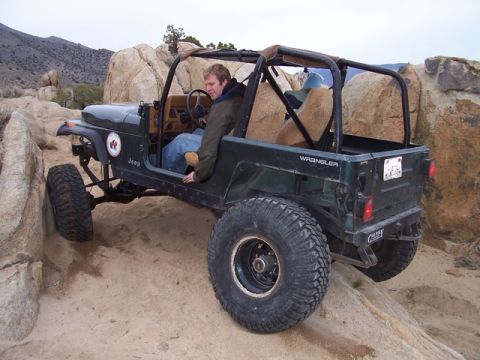 1989 Ford Bronco - A Jeep Wrangler navigates a challenging rocky terrain, its off-road capabilities.