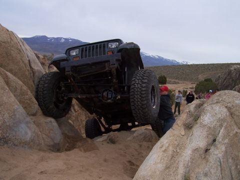 1989 Ford Bronco - A Jeep Wrangler navigates a challenging rocky terrain during an off-road event.