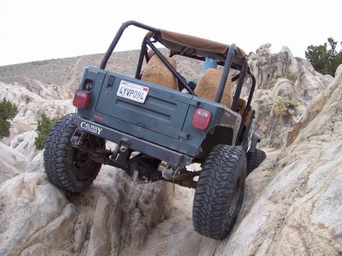 1989 Ford Bronco - A green Jeep Wrangler navigates a rocky trail during Spring Break 2005.