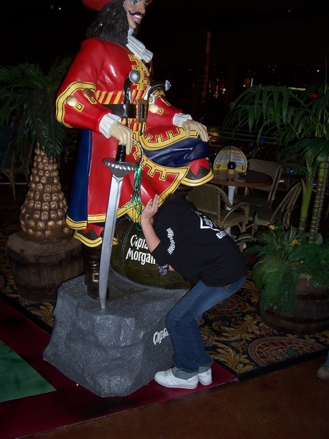 1989 Ford Bronco - A person hides behind a large statue of Captain Morgan, with the brand's name visible on a barrel.