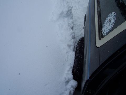 1989 Ford Bronco - This vehicle appears to be stuck in a snowdrift, with only its side and tire visible.