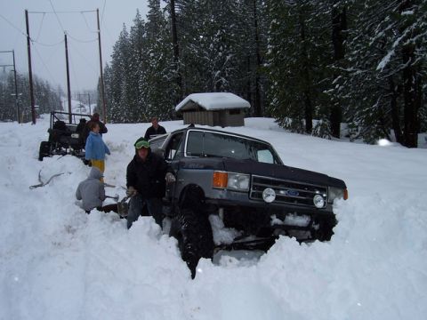 1989 Ford Bronco - A group of people attempt to free a Ford Bronco from a snowdrift.