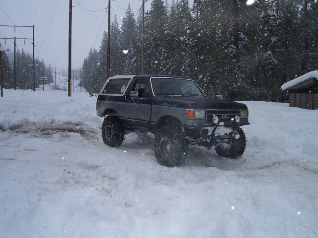 Lifted Ford Bronco in the snow, front end visible with aftermarket bumper and lights