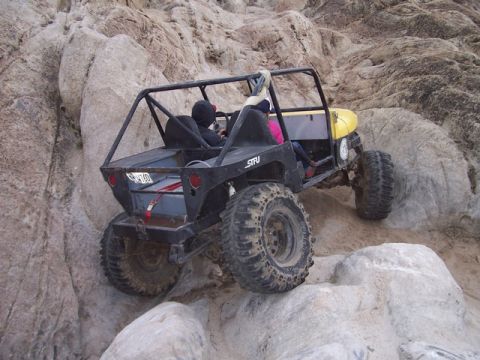 1989 Ford Bronco - This custom buggy is navigating a rocky trail, its off-road capabilities.