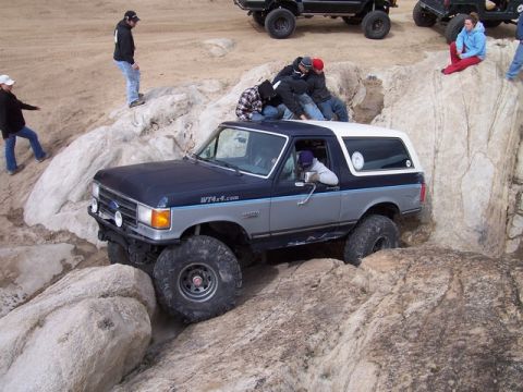 1989 Ford Bronco - Ford Bronco tackling a challenging rock crawling course with spectators.