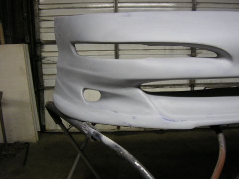 1994 Ford Probe - Car bumper is prepped for paint and mounted on a stand.