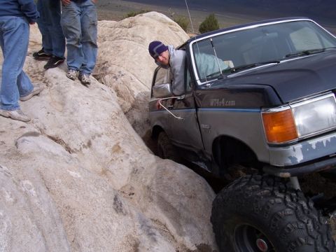 1989 Ford Bronco - A lifted 1987 Ford Bronco is shown navigating a rocky trail with several people watching.